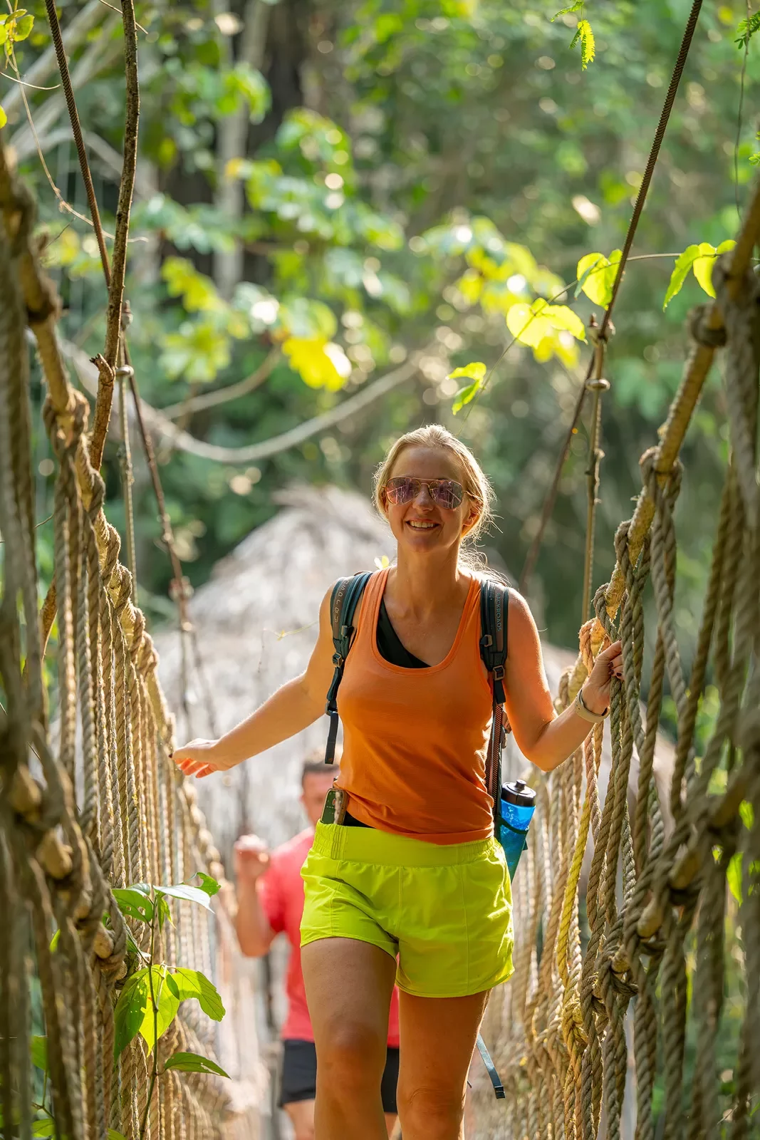 Female walking along a rope bridge in the forest