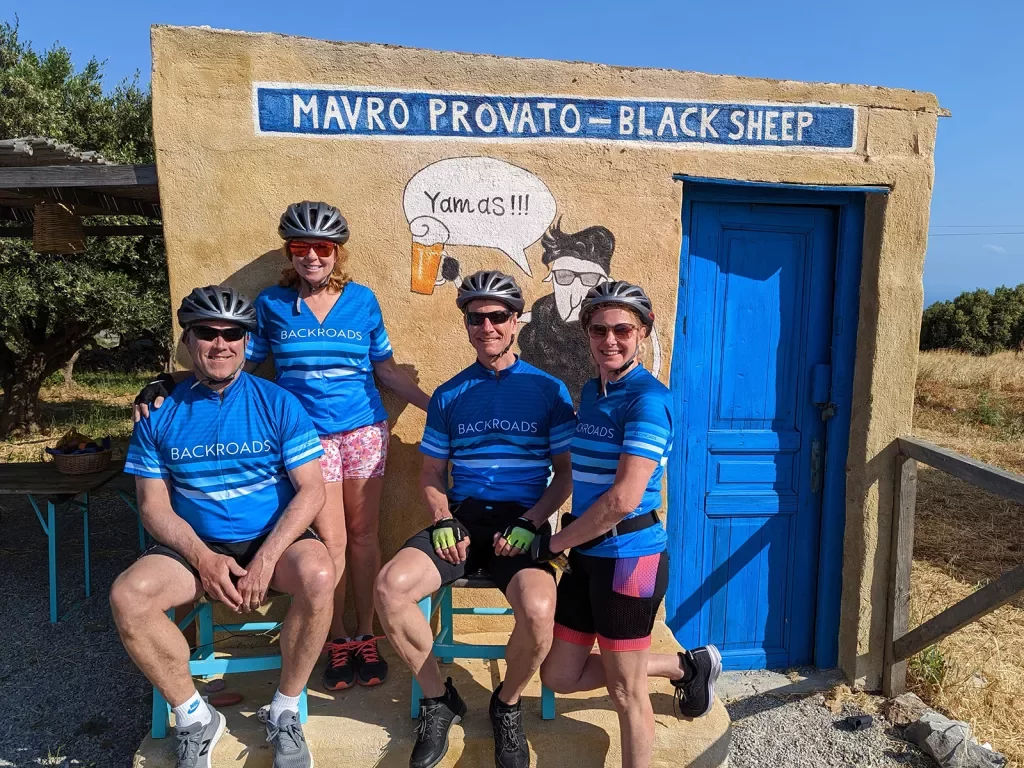 Four guests in biking gear at small rest point building. 