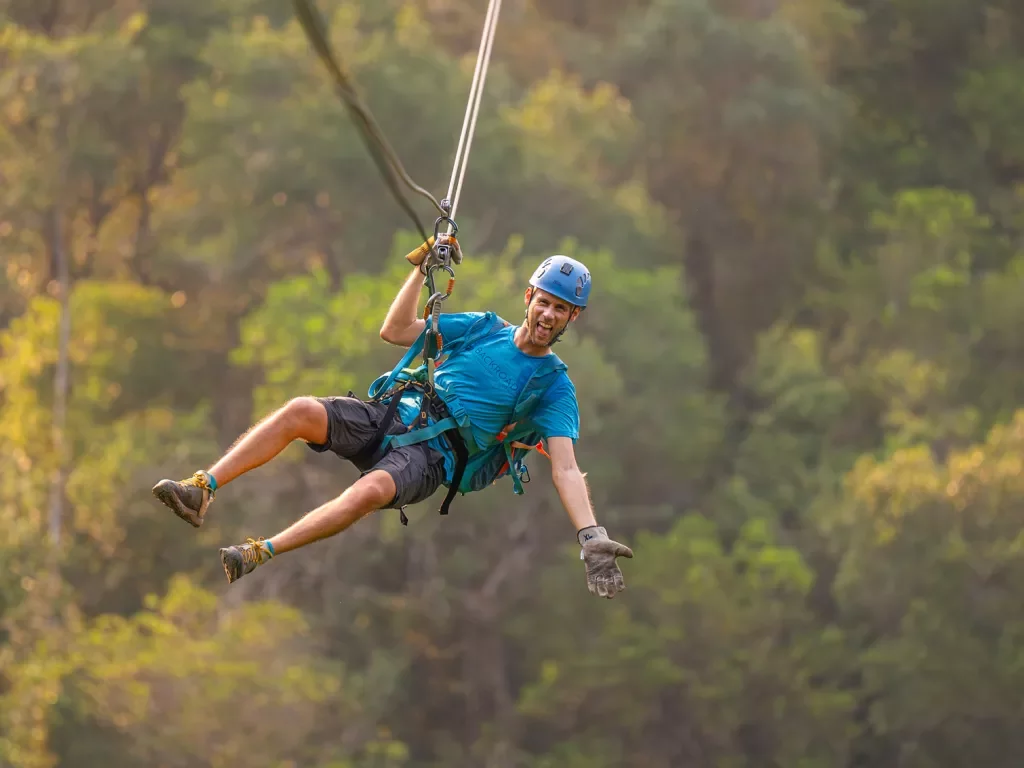 Man ziplining in the middle of the forest