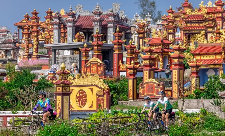Bikers cycling through red and yellow temples