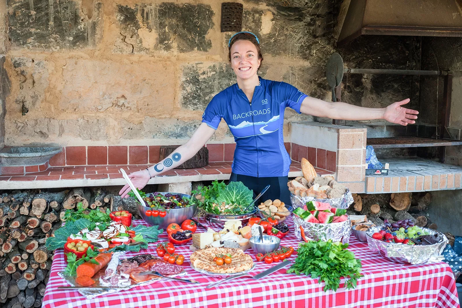 Backroads leader posing with table of Spanish food and snacks.