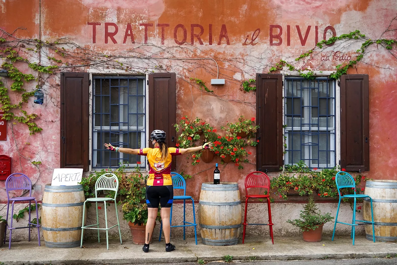 Storefront of &quot;TRATTORIO IL BIVIO&quot;, guest with their arms outstretched.