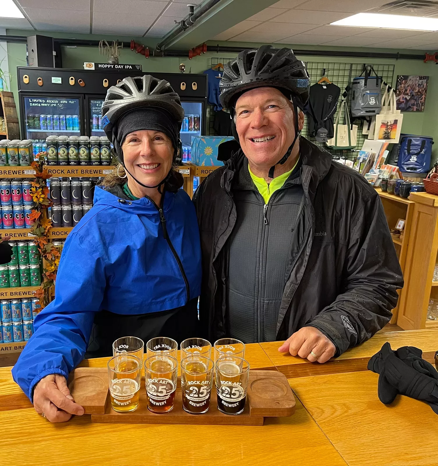 Two guests in store, posing with beer flight.