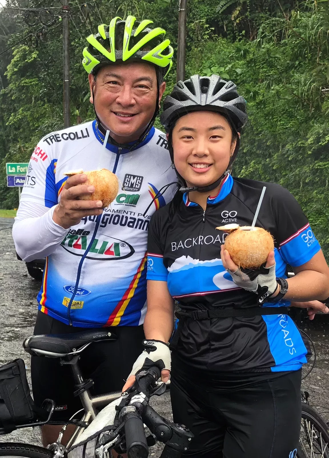 Two Cyclists Drinking Coconuts