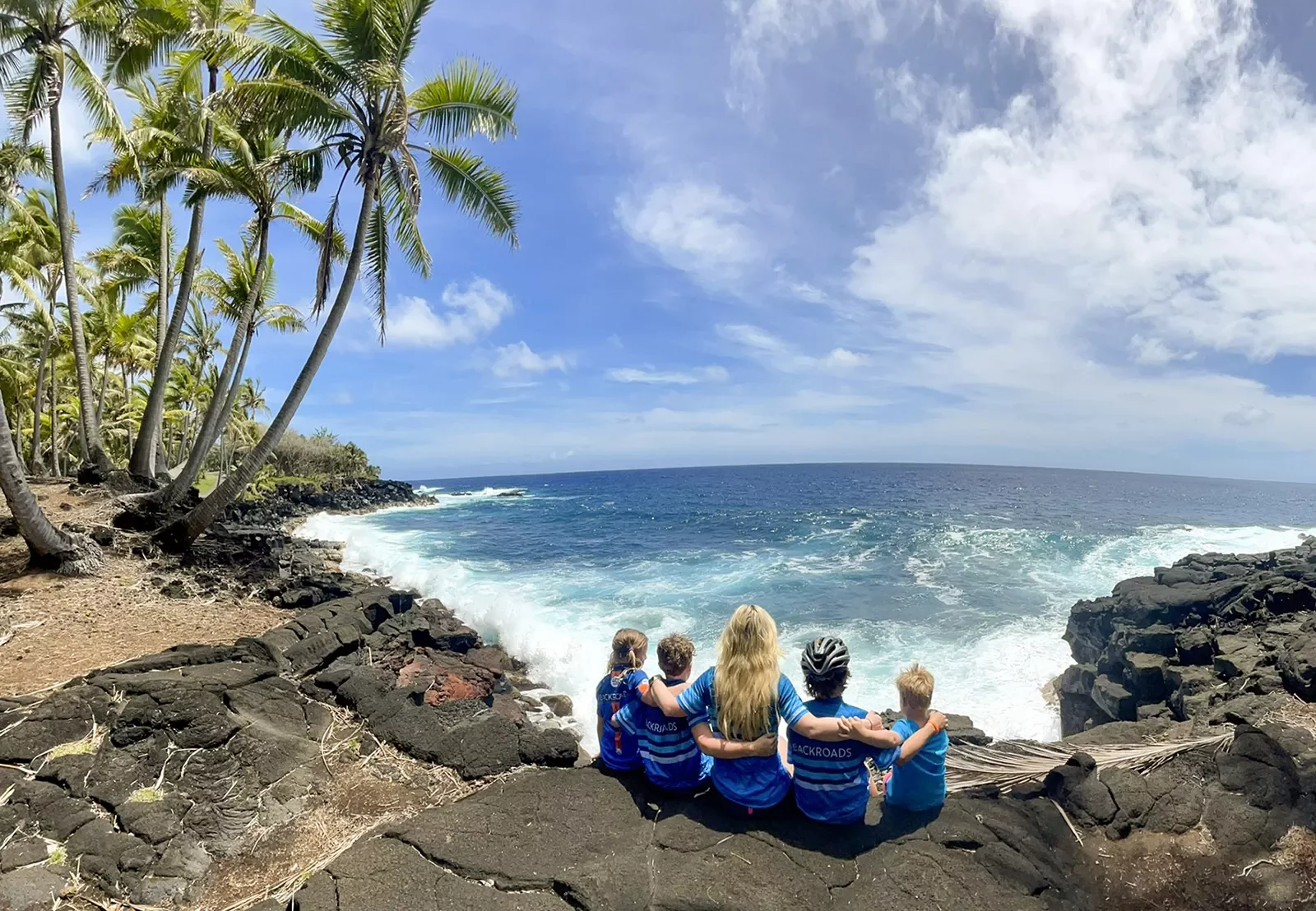Family sitting by the ocean in Hawaii