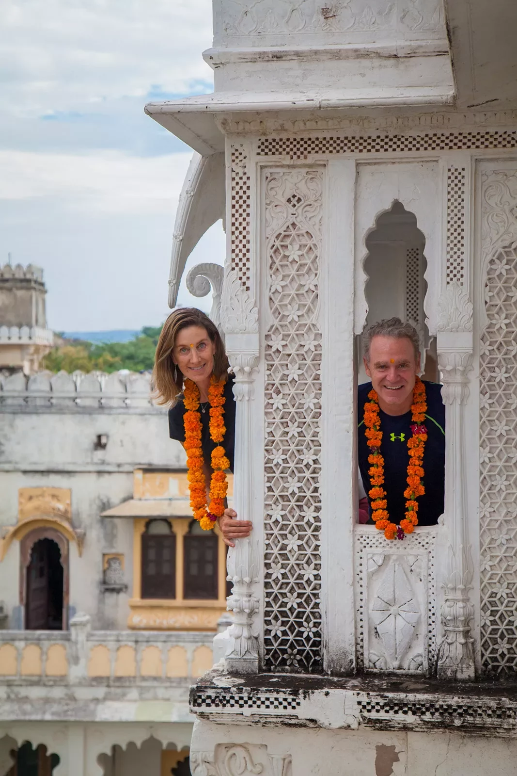Backroads guests peeking through windows of an ornate white building in India