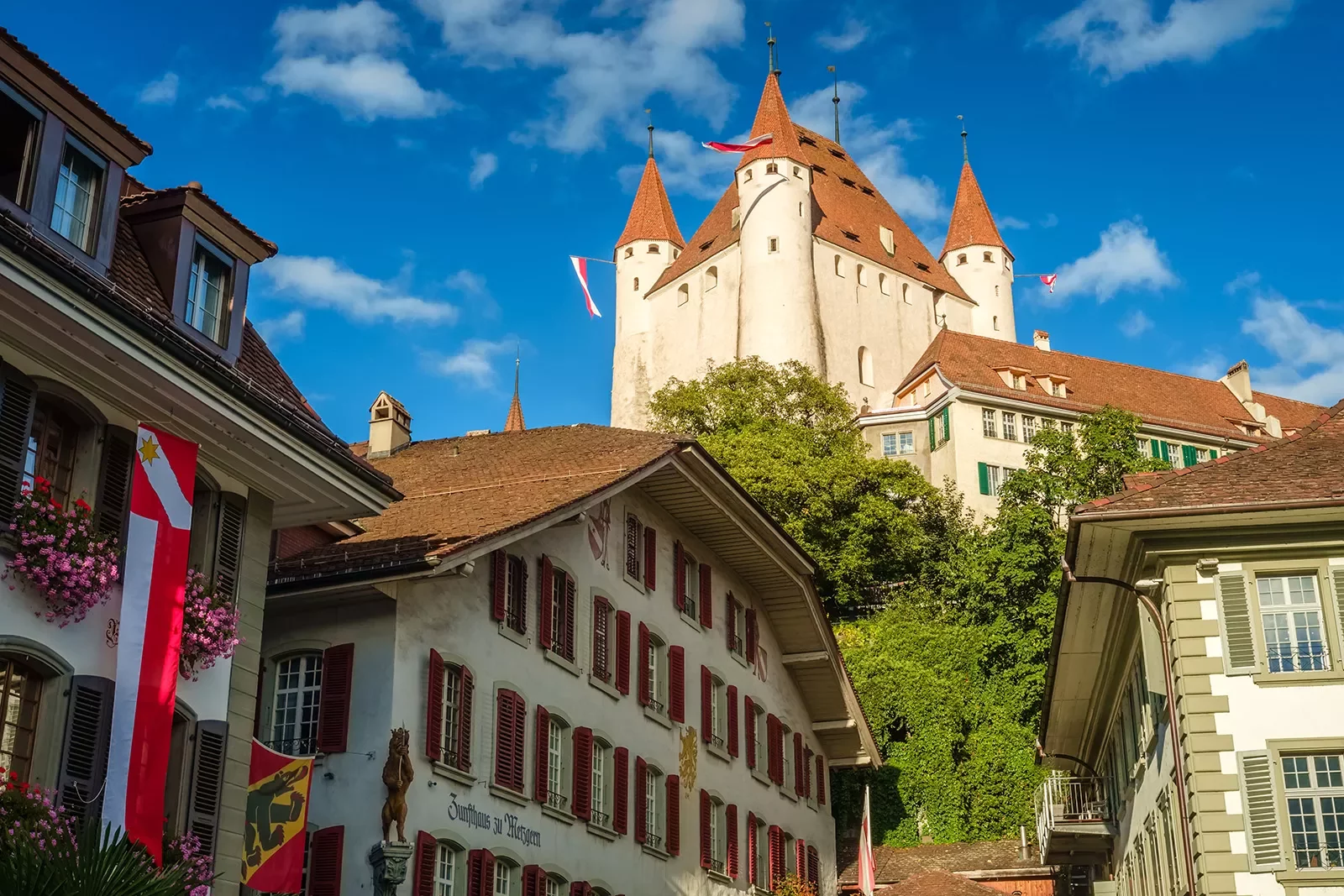 Ground-angle shot of Thun Castle, German architecture all around.