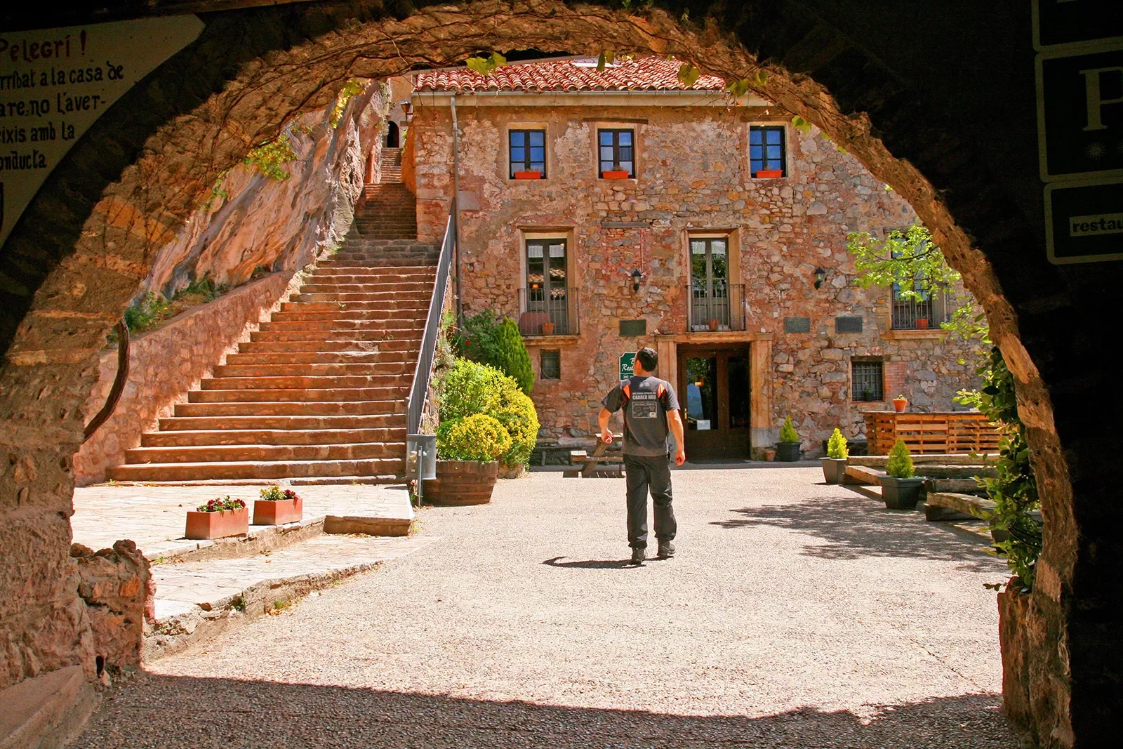 Archway shot of guest amid red brick courtyard.