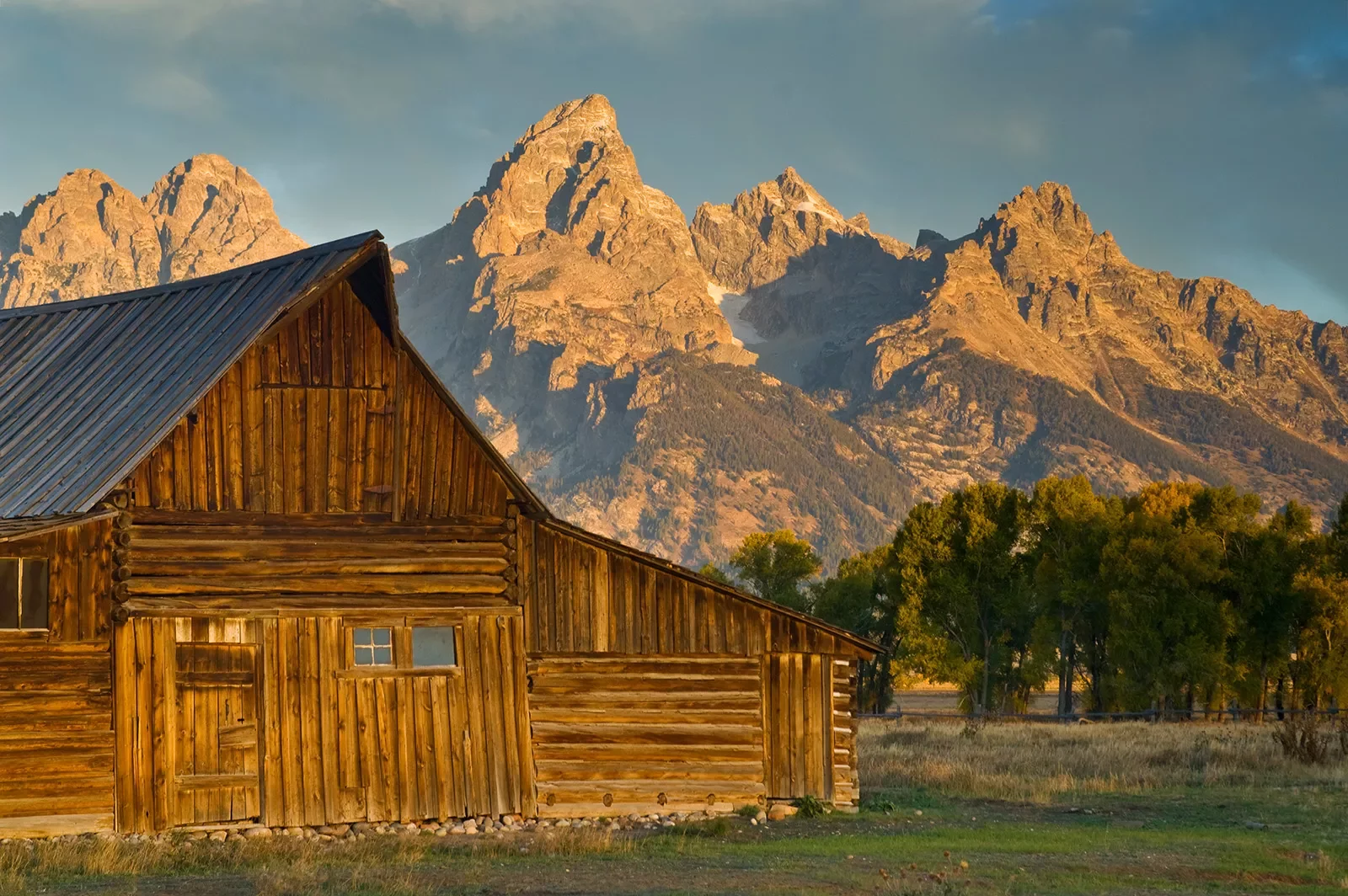 Wooden cabin with rocky mountains in background