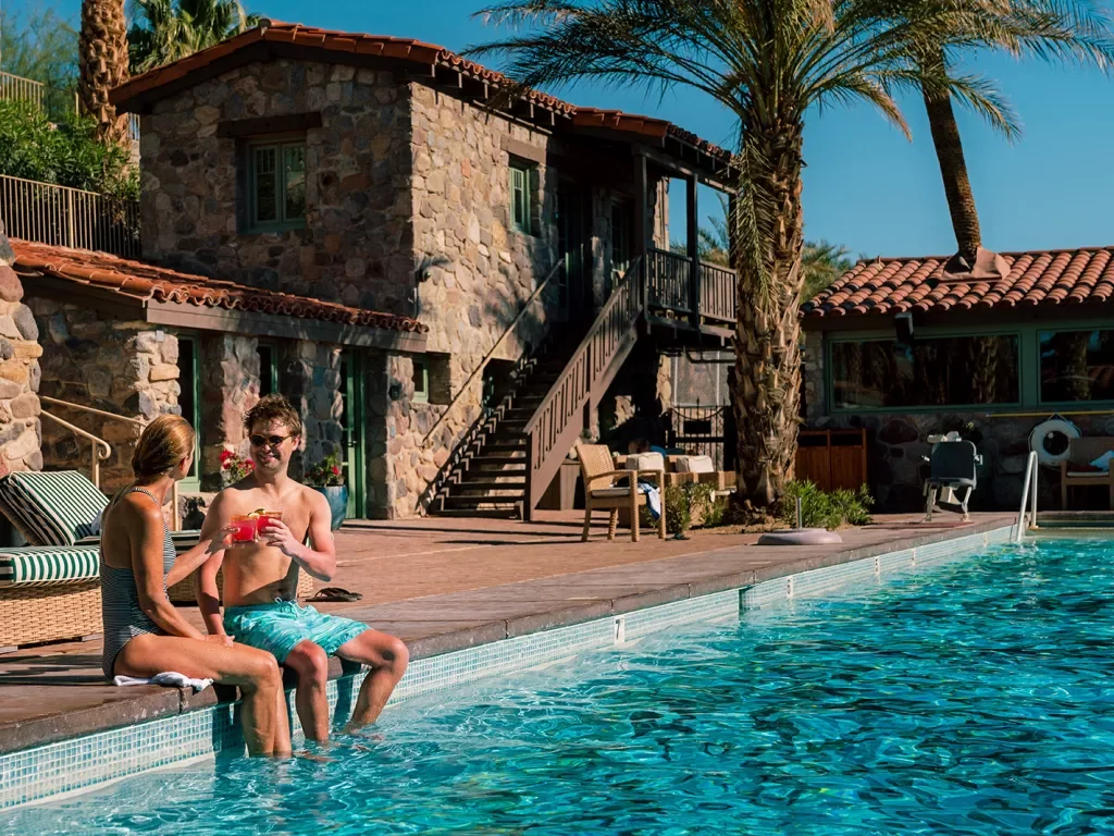 Guests relaxing poolside at desert resort.