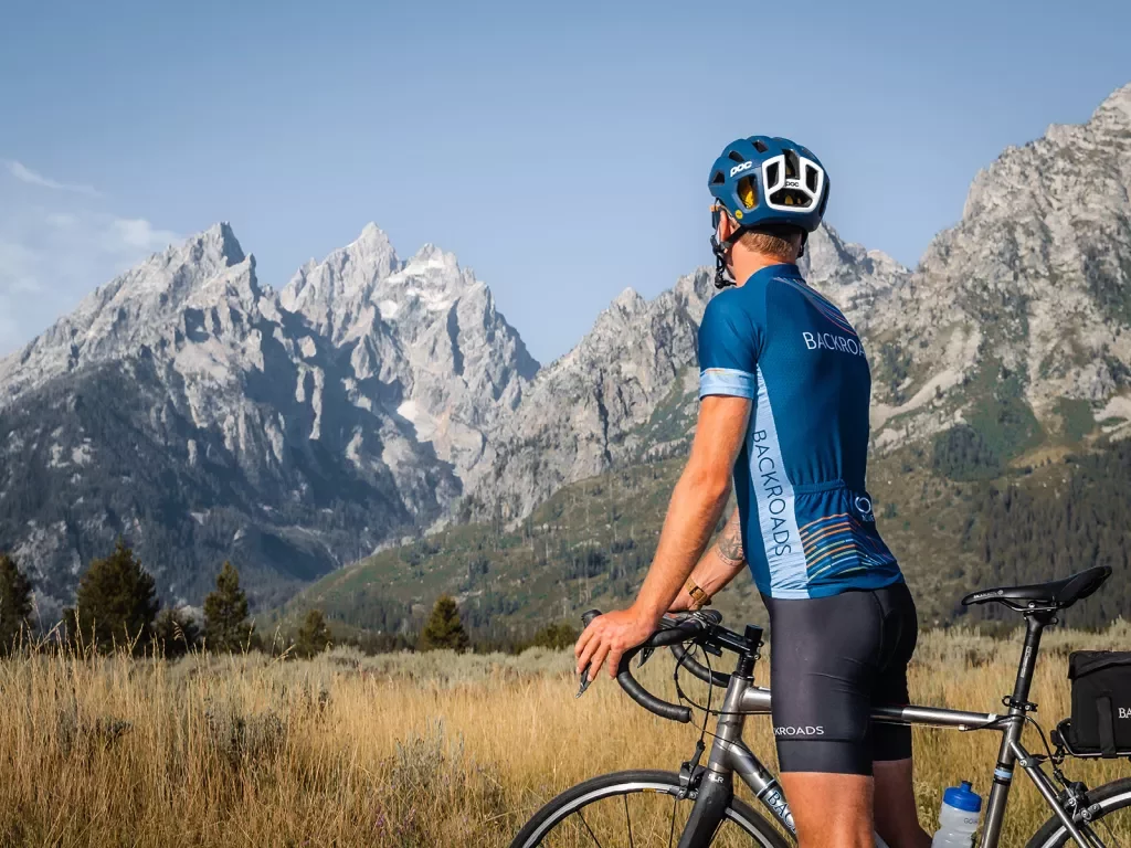 Backroads guest stopping on bike to appreciate mountains