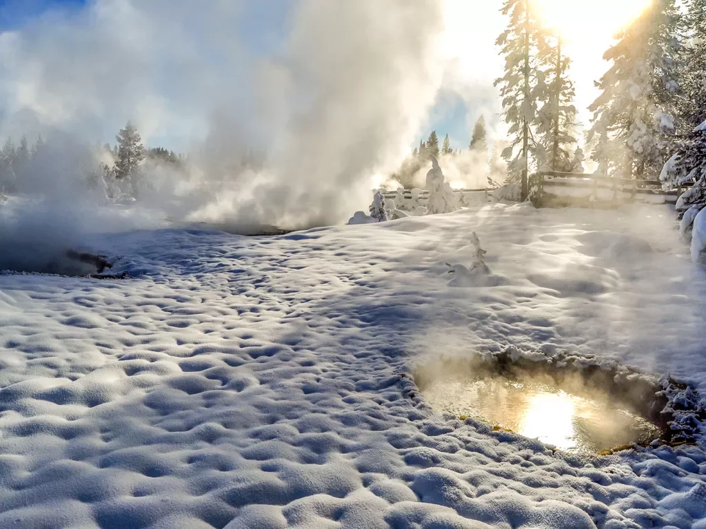 Snow covered landscape and hot springs with steam