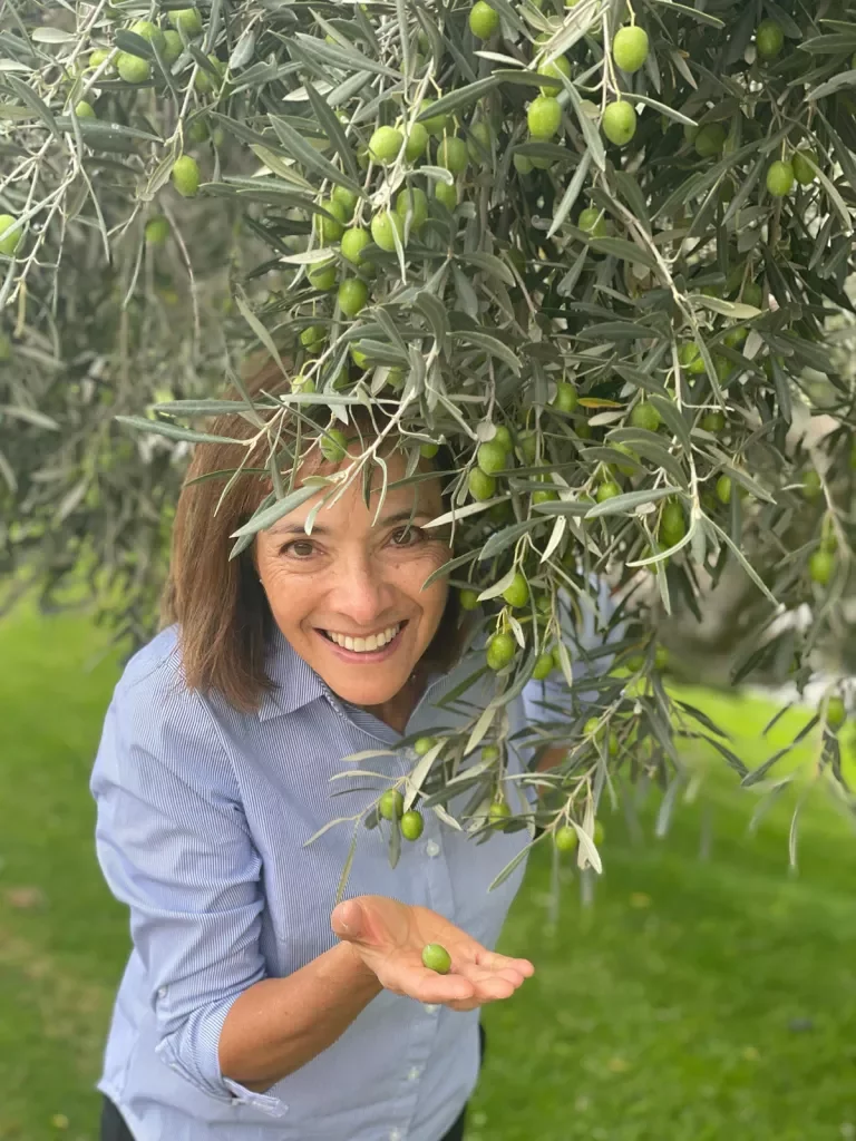 Woman posing with olive tree.