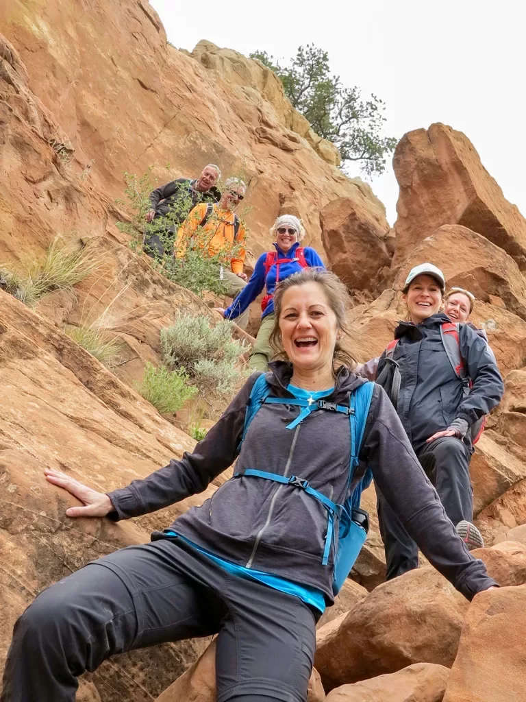 Guests smiling while climbing down boulders