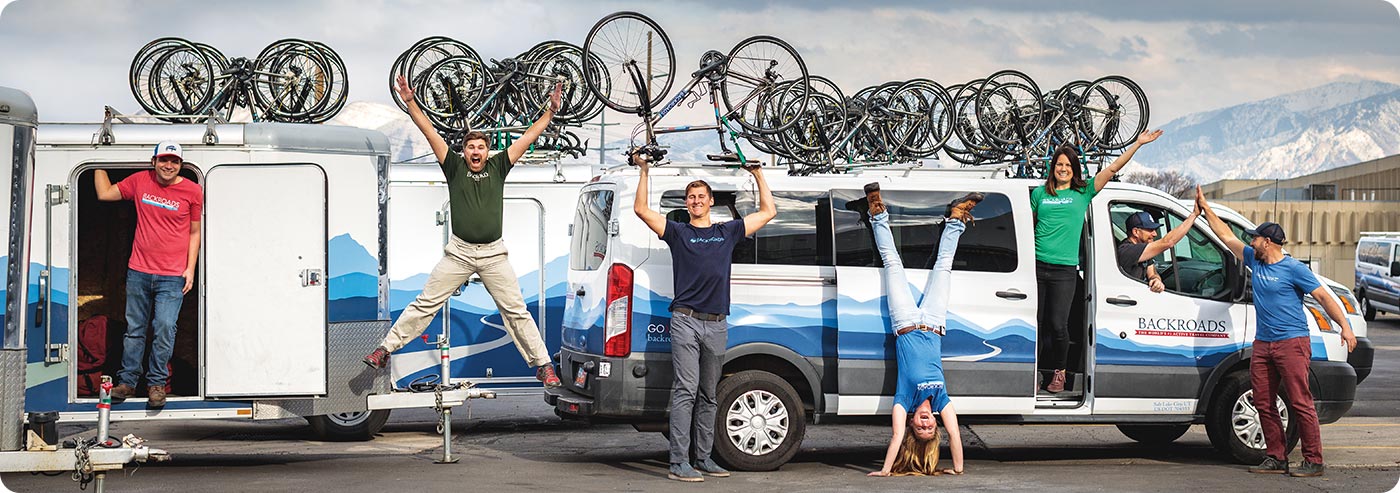 Backroads Leaders posing with bikes, vans & trailers