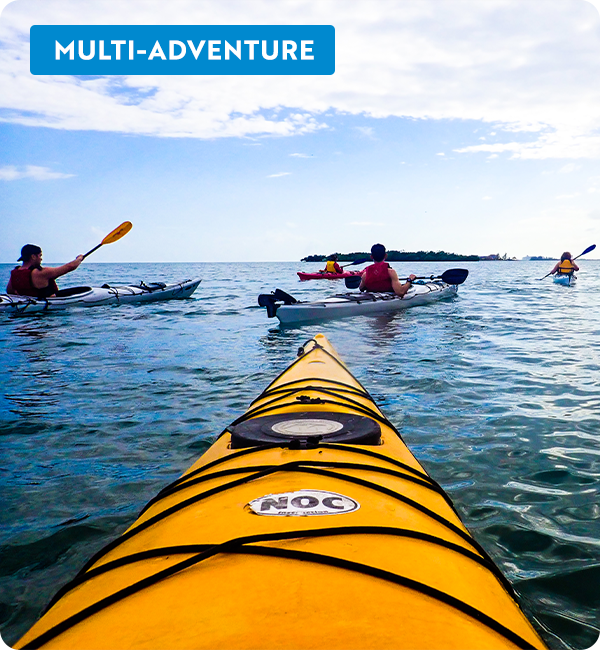 View from a kayak on the water, other kayakers in the distance