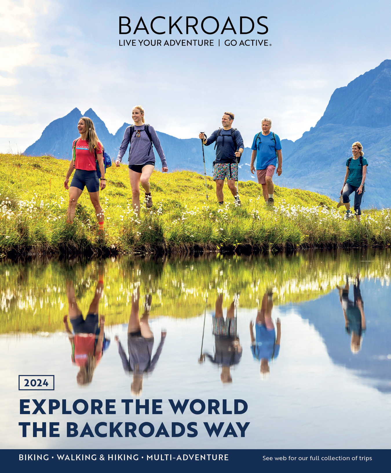 Group of hikers along water with their reflections 