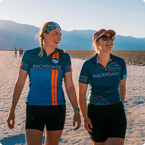 Two young women walking and laughing on a sunny day in the desert