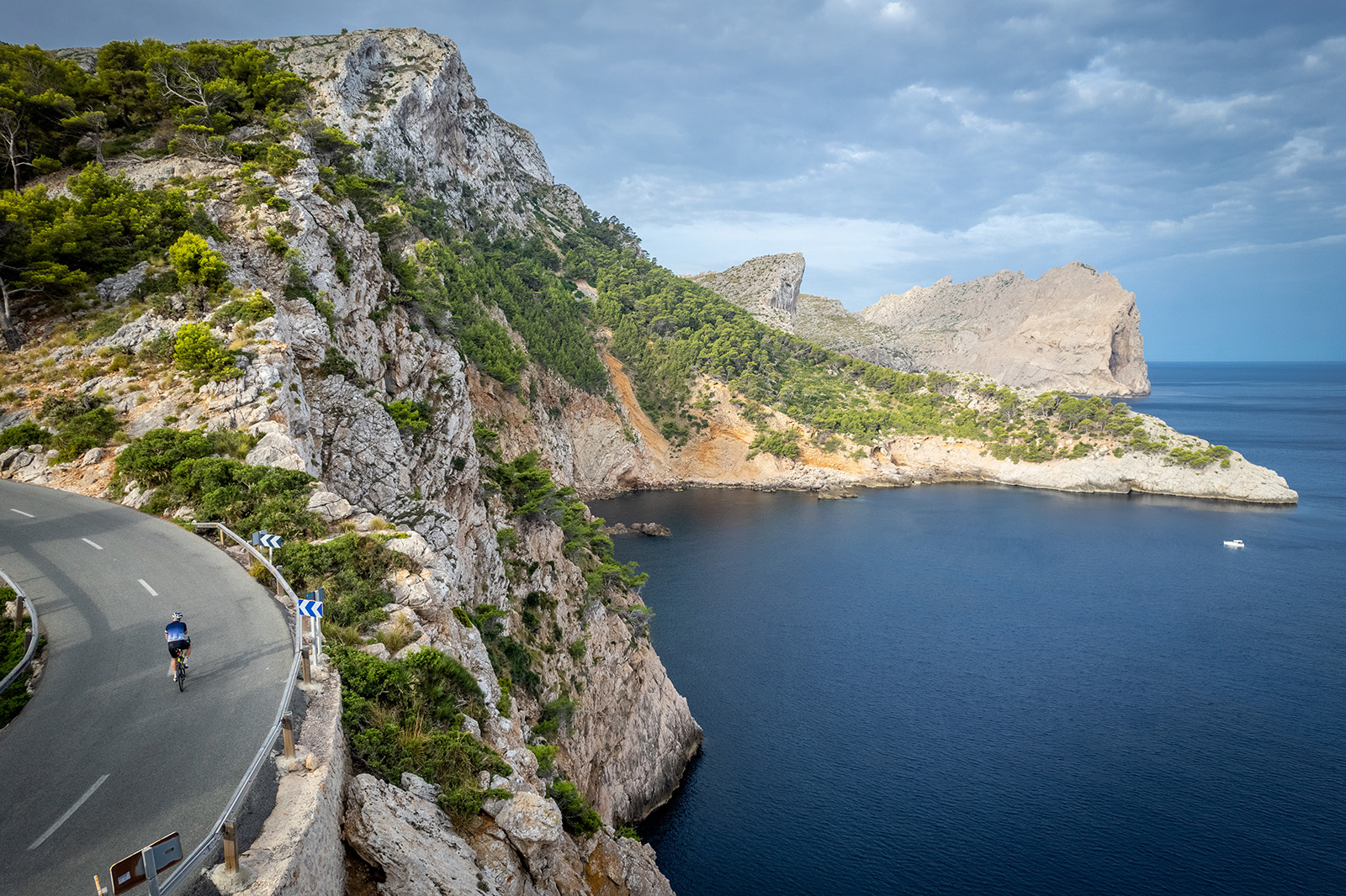Biker riding around a bend on the coast of Mallorca.