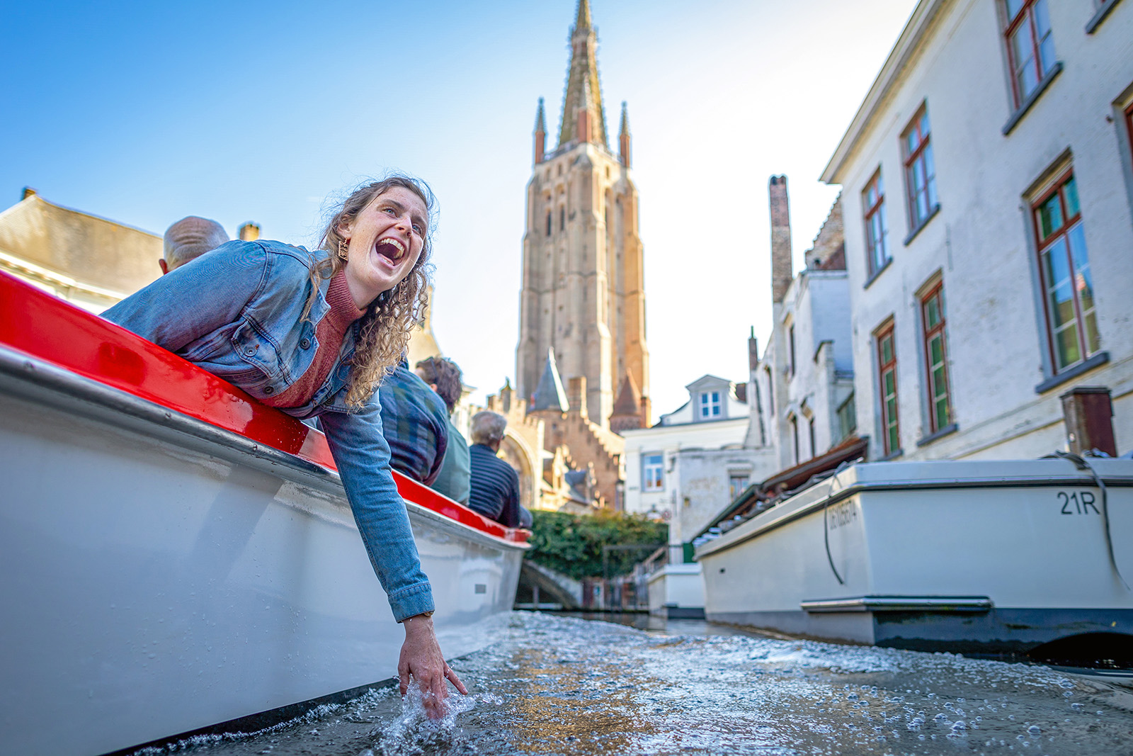 Guest dipping hand in water on boat