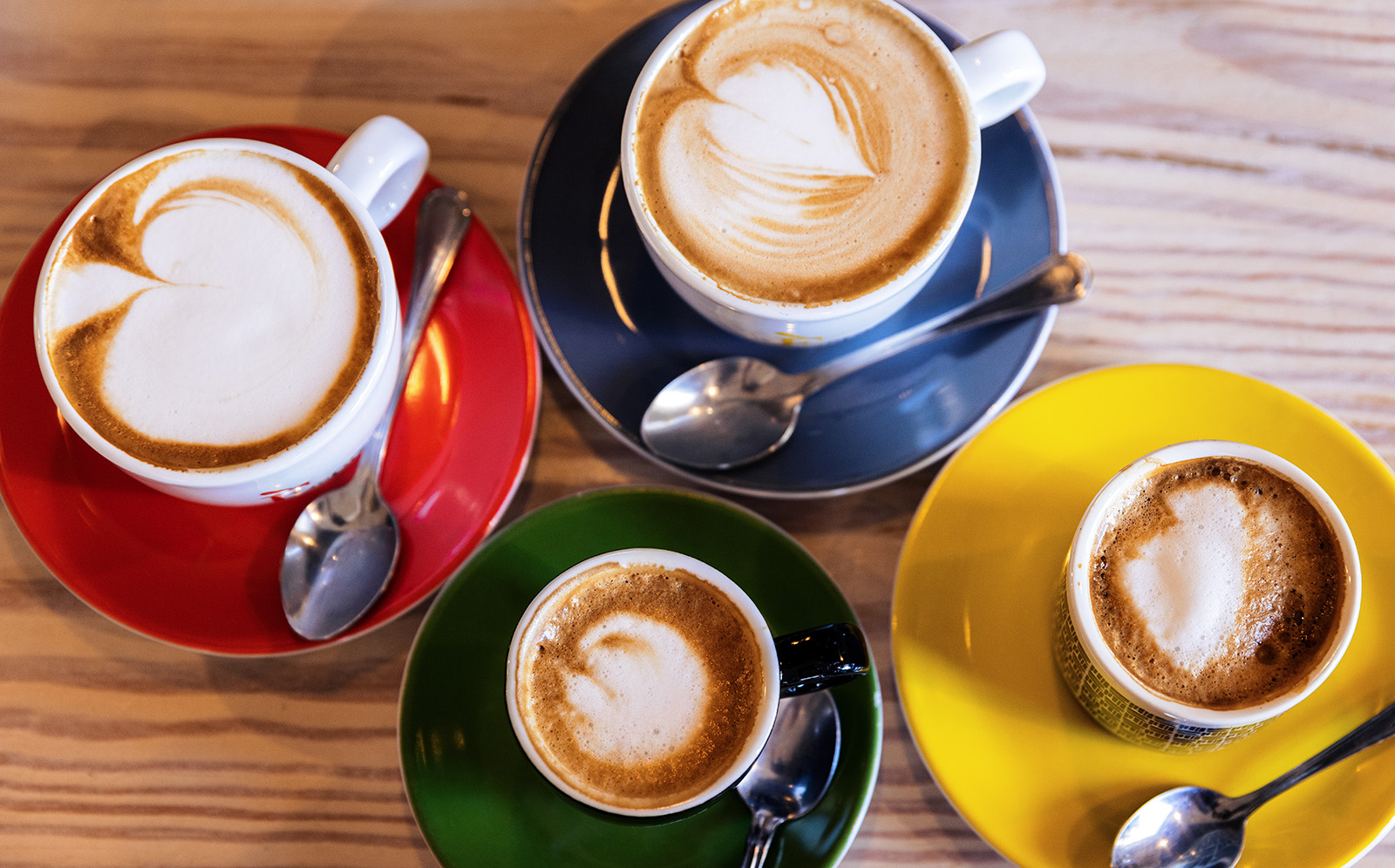 Close-up of four full coffee mugs.