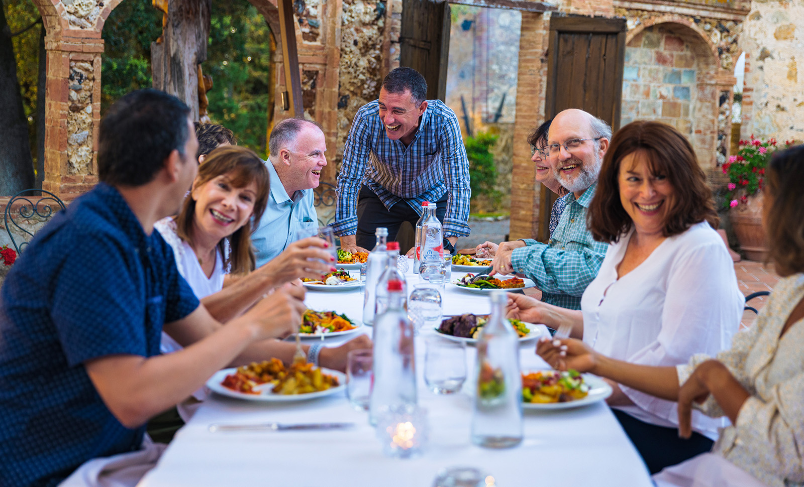 Group of guests at dinner, smiling and laughing.