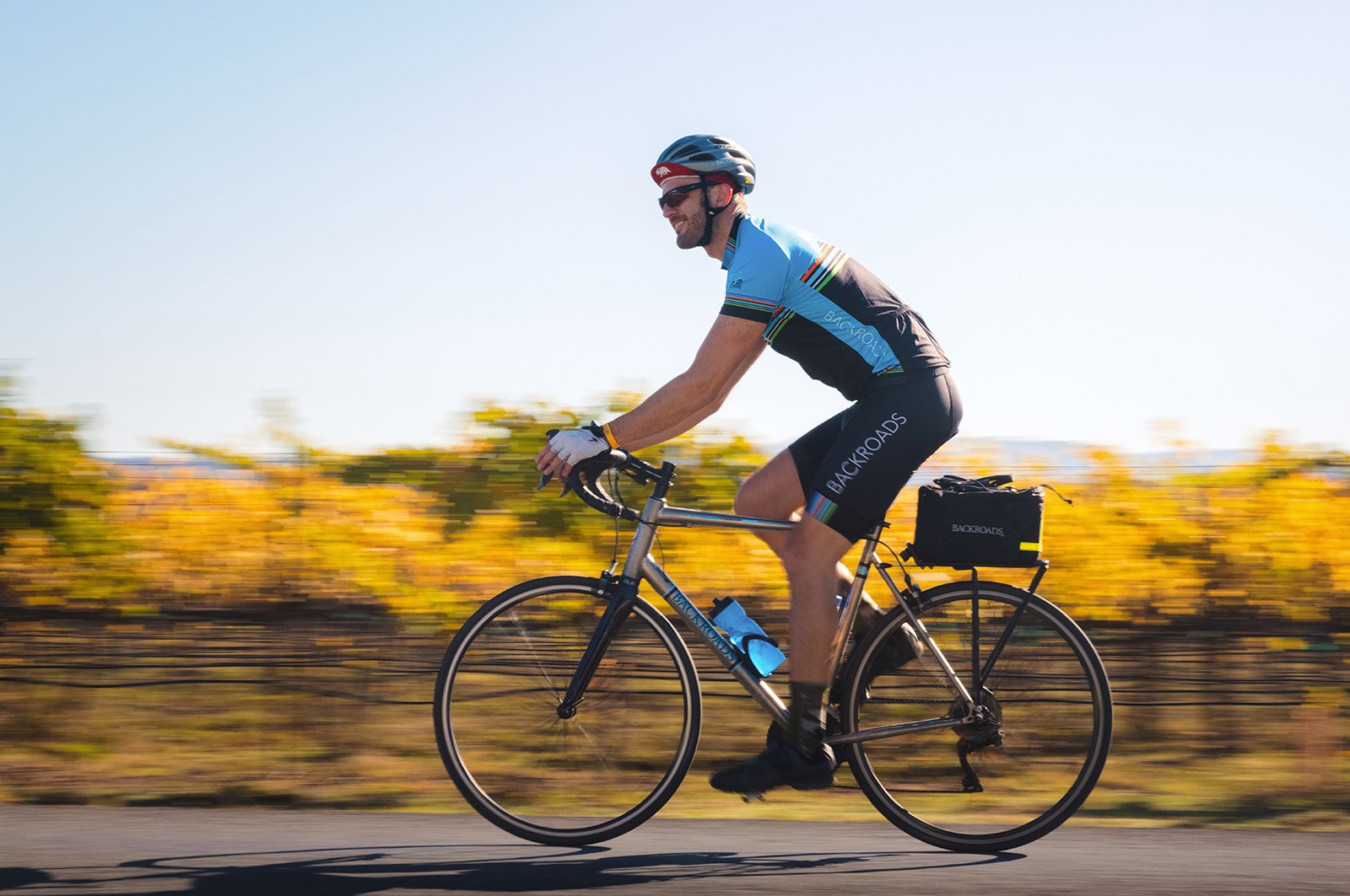 Guest cycling past yellow vineyard.