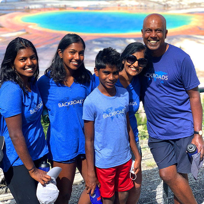 Family standing in front of Grand Prismatic Springs in Yellowstone National Park