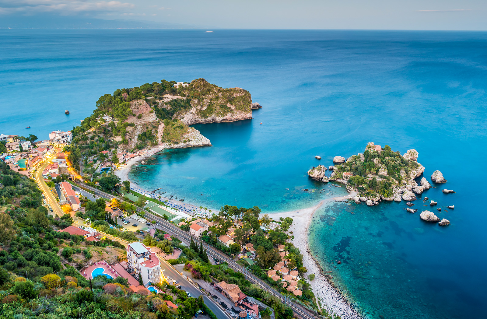 Bird's eye shot of colorful Italian coastline. Blue water and multi-colored houses.