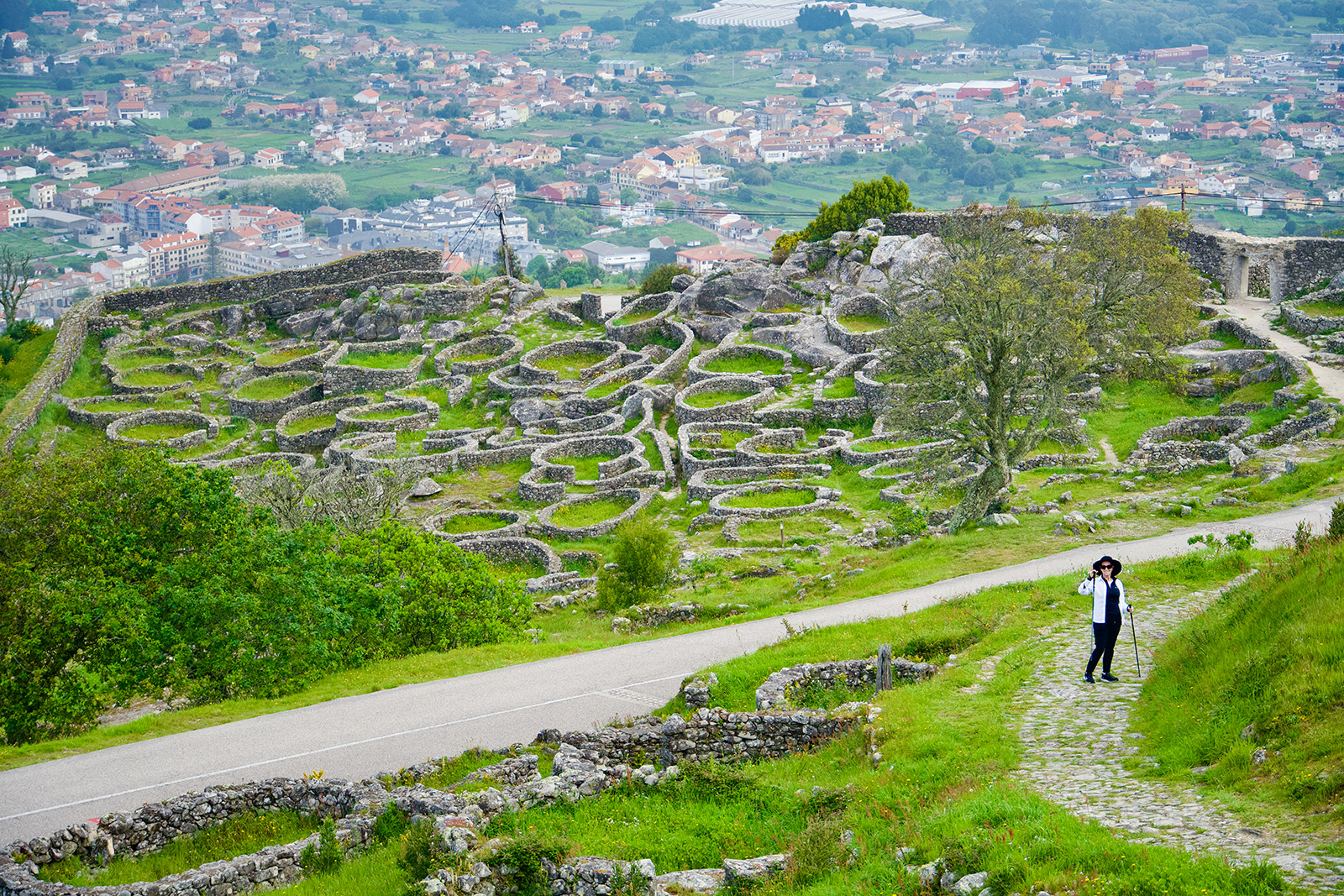 Hiker on Camino de Santiago with town in the backround