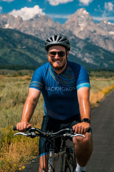 Man smiling while riding a bike in a valley