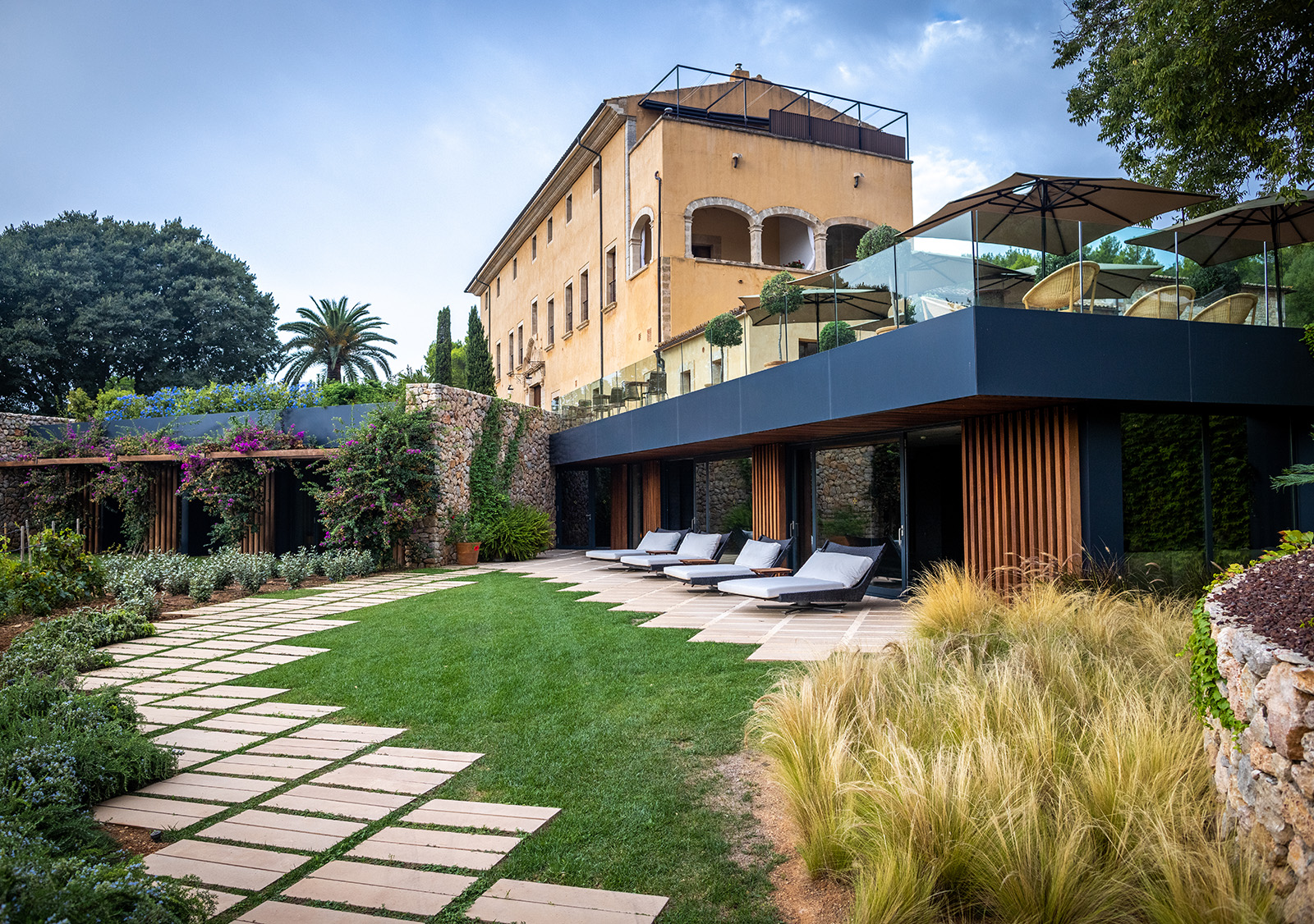 hotel with lots of outdoor seating and manicured gardens