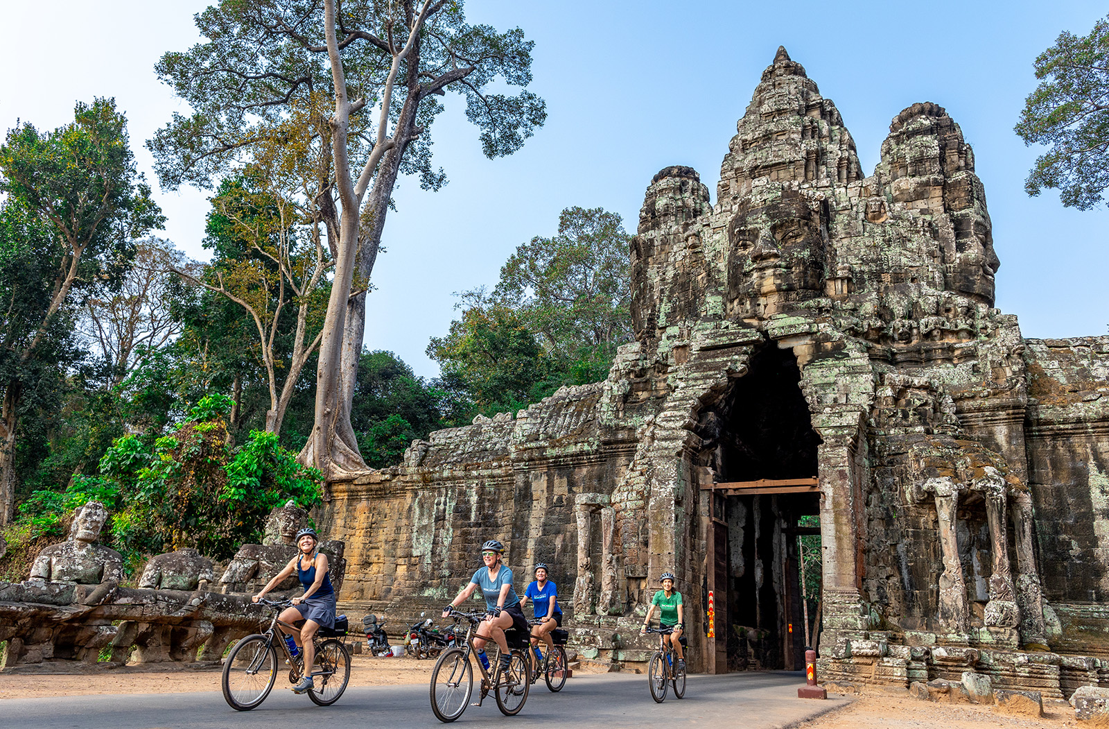 people bike through a covered bridge
