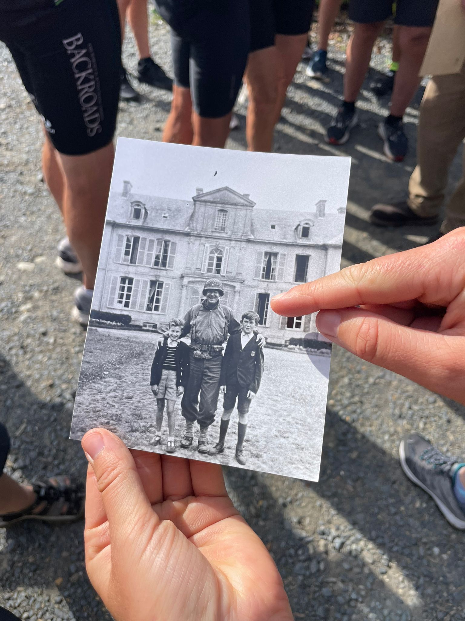 Black and white photo of a soldier with arms around 2 boys