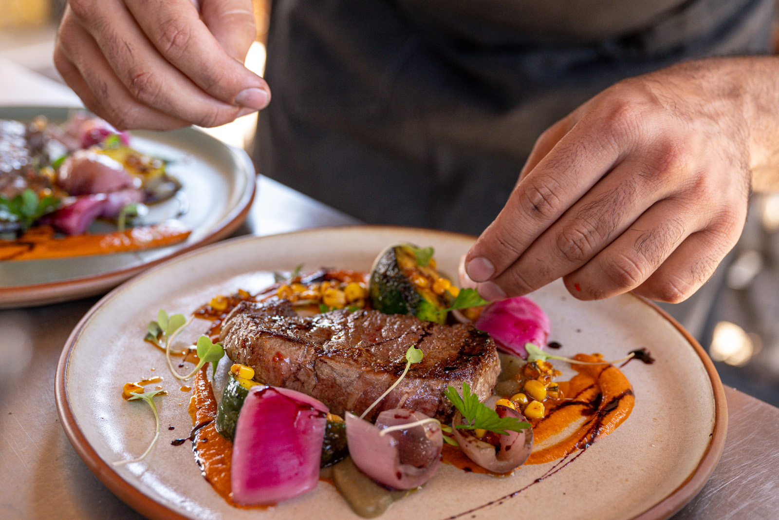 hands plating a steak