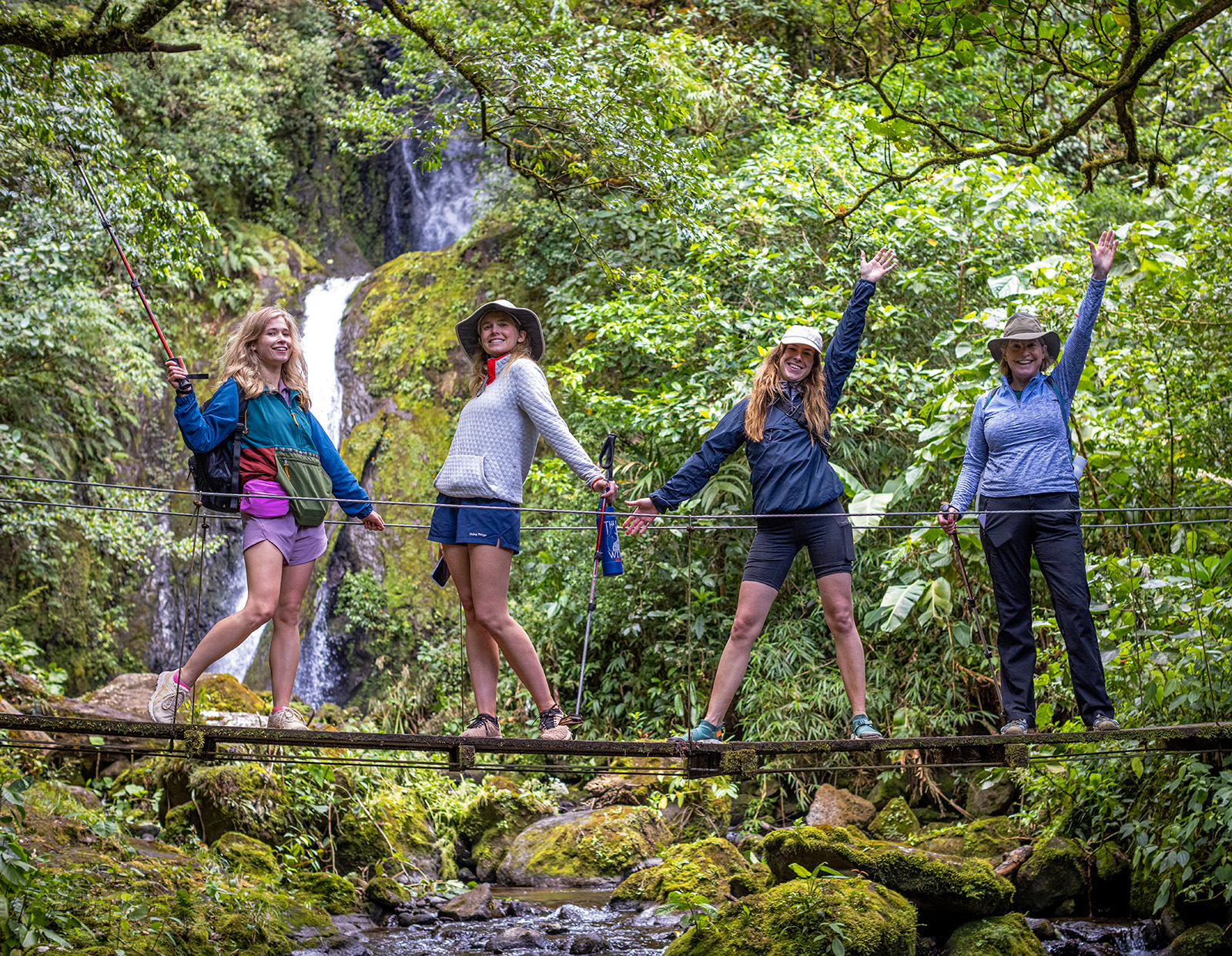 4 women standing in front of trees