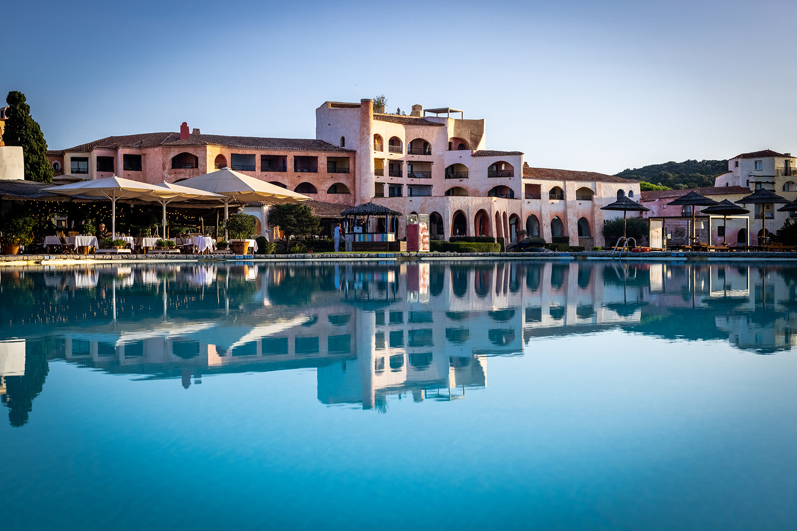 Stone hotel building with a pool in front