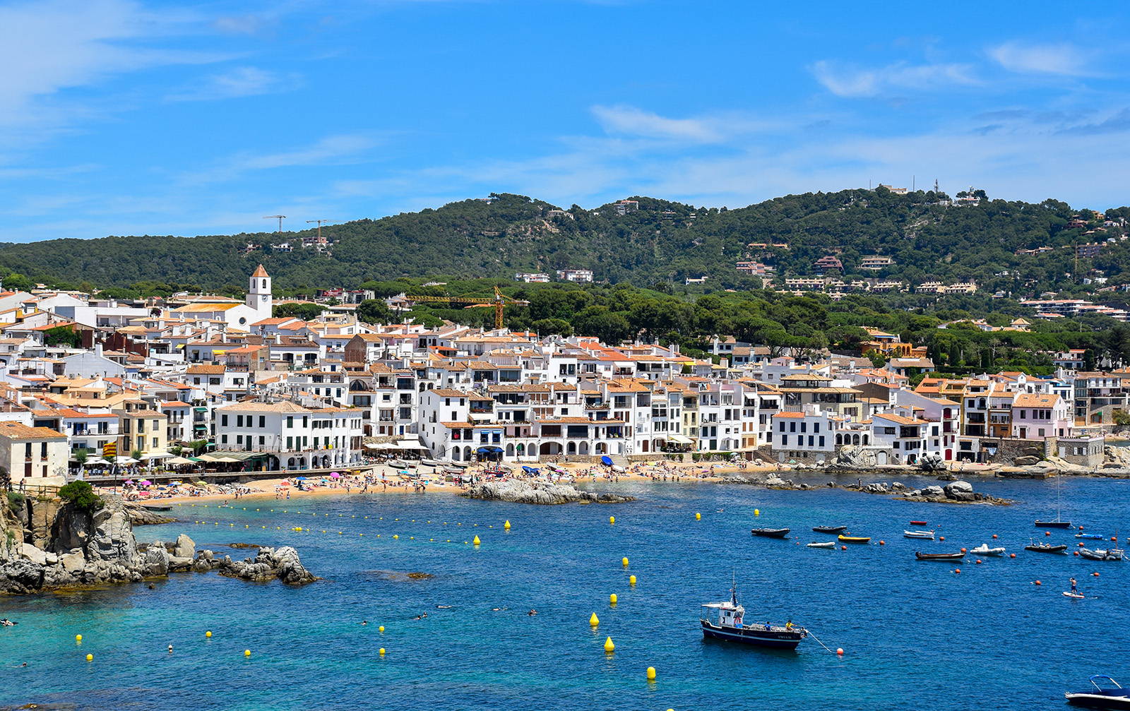 Beach-side town next to the ocean and boats floating in the water