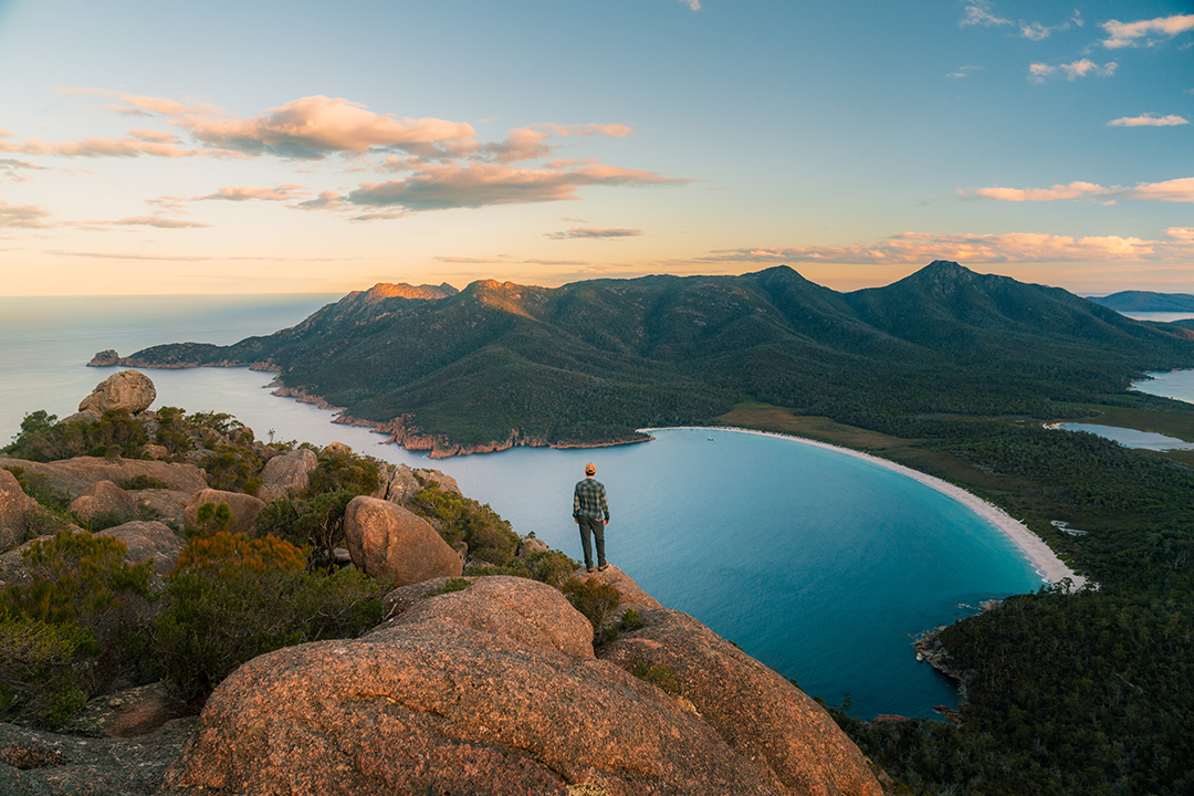 Man standing on hill overlooking lake