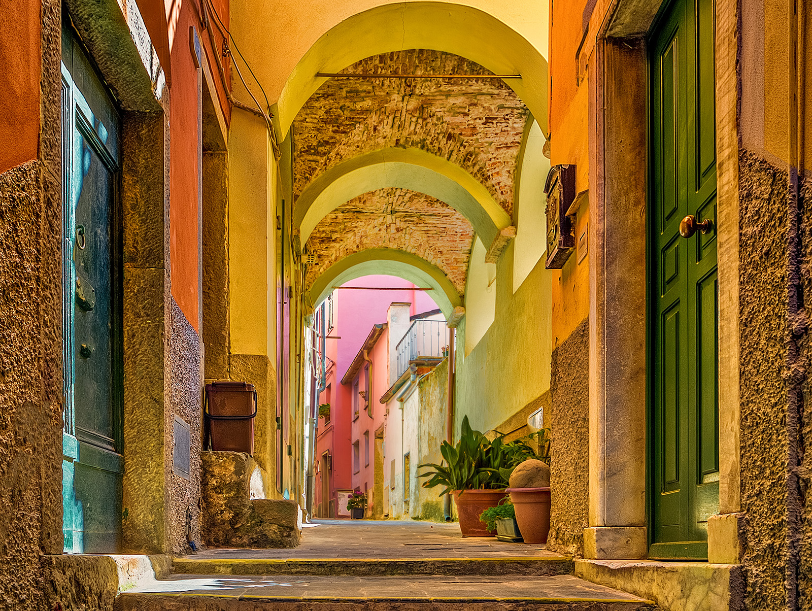 Stone alleyway leading to colorful buildings