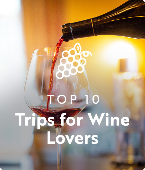 Text: Top 10 Trips for Wine Lovers; Image: Wine glass being poured