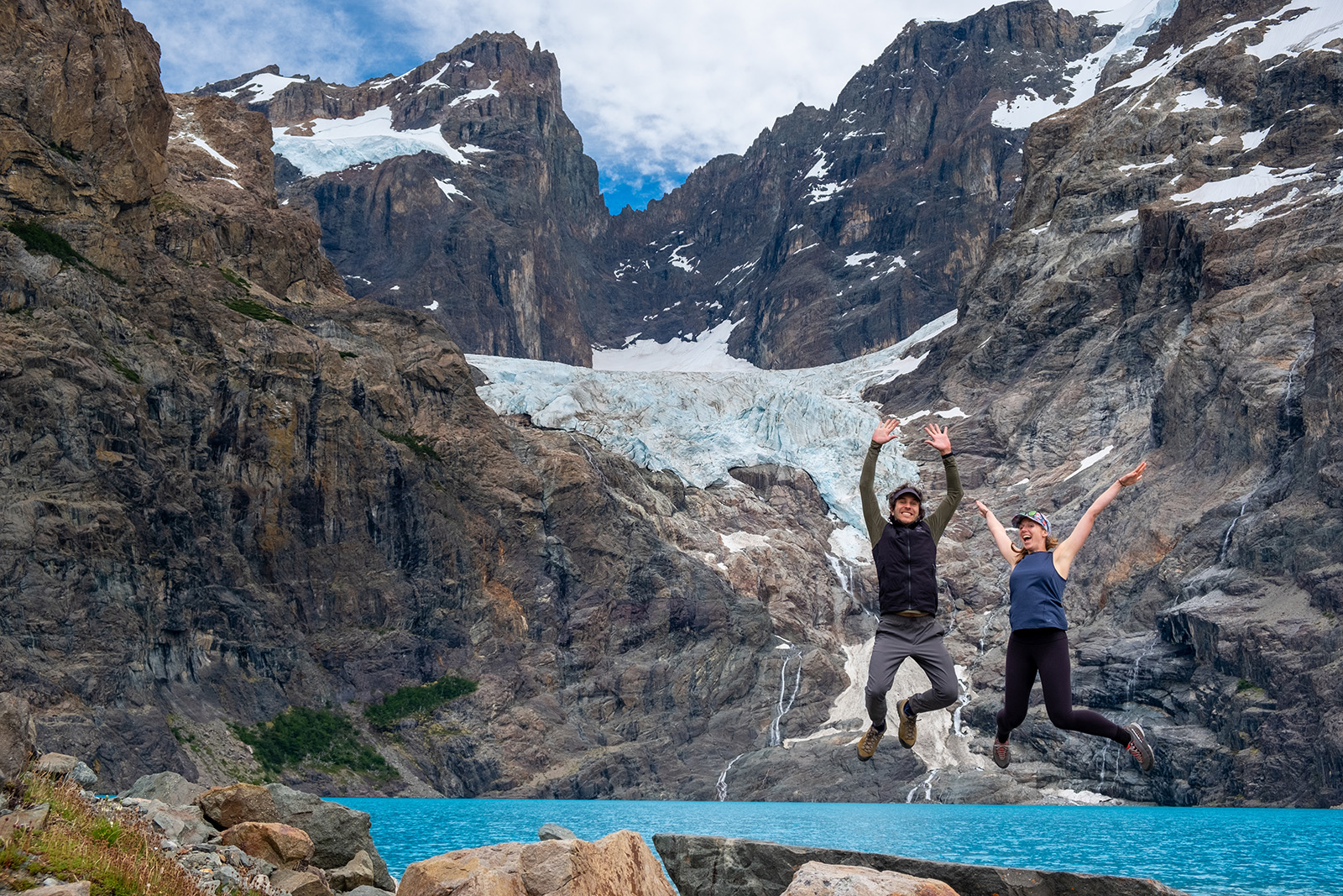 Man and woman jumping in front of mountain