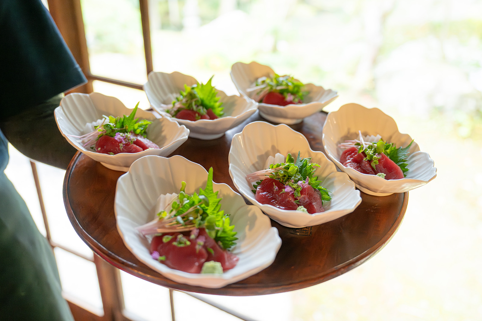Six plates of raw fish with greens