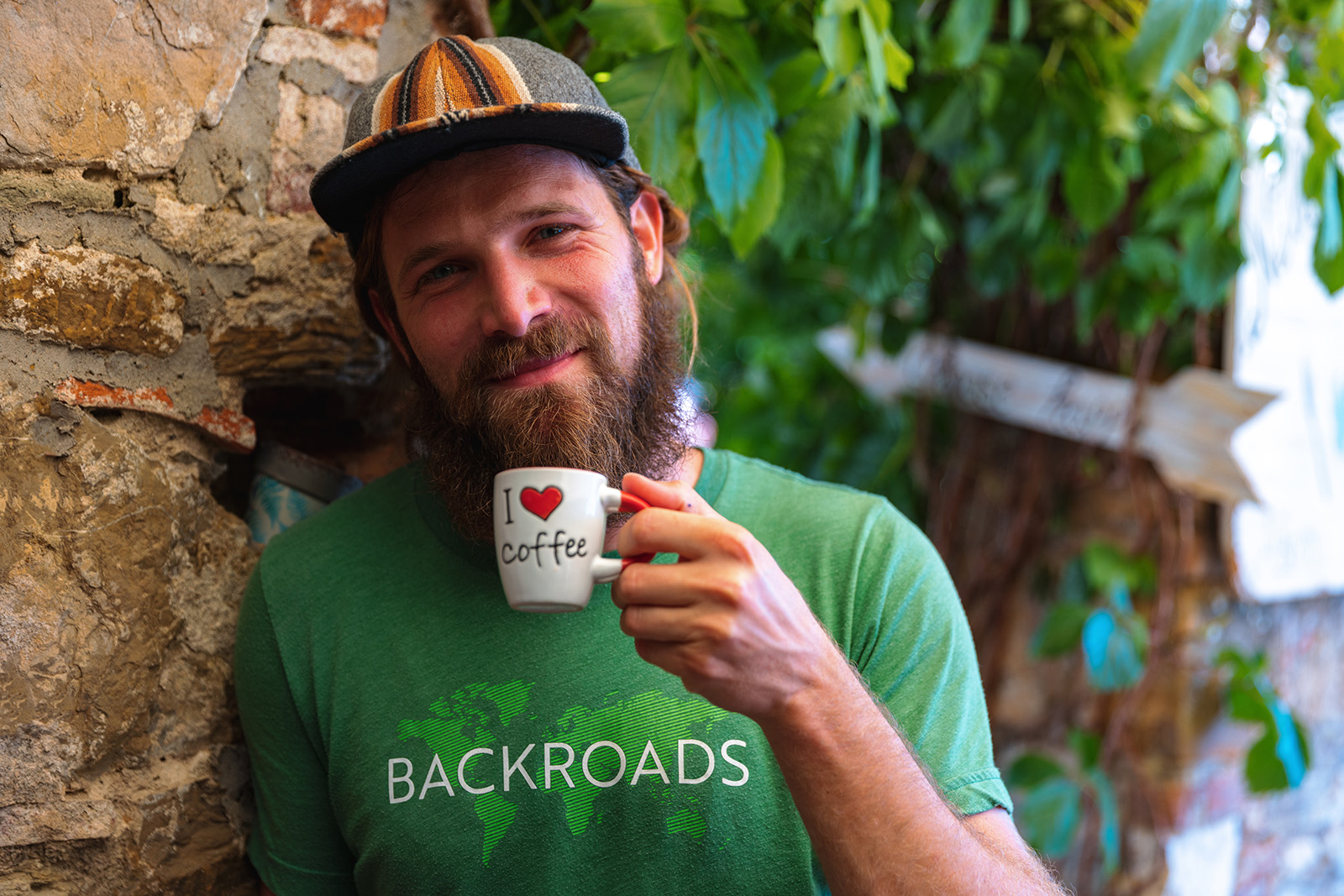 Man in a green shirt drinking from a mug