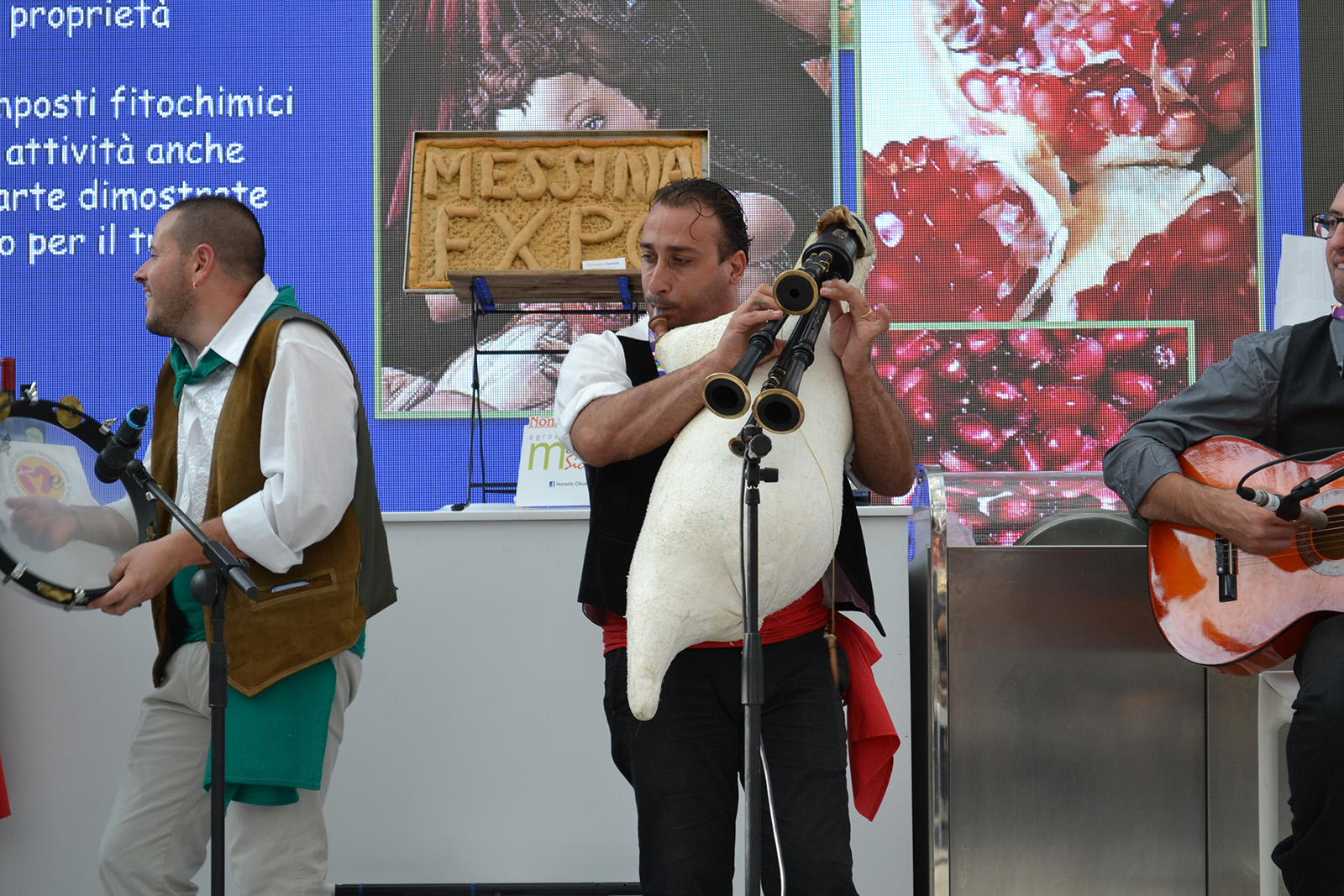 Group of men playing the guitar, tambourine and a bagpipe