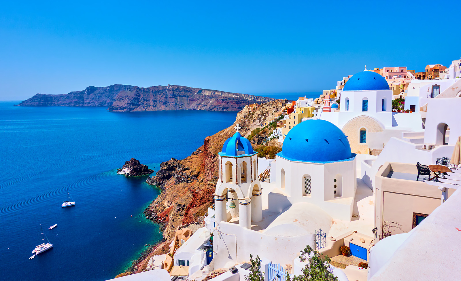 Greek coastline with white buildings along a cliff