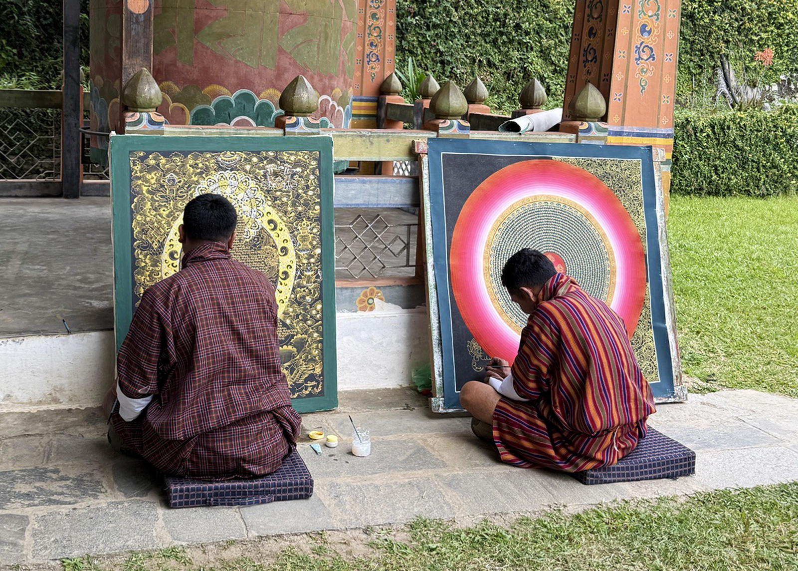 Two monks kneeling in front of a temple