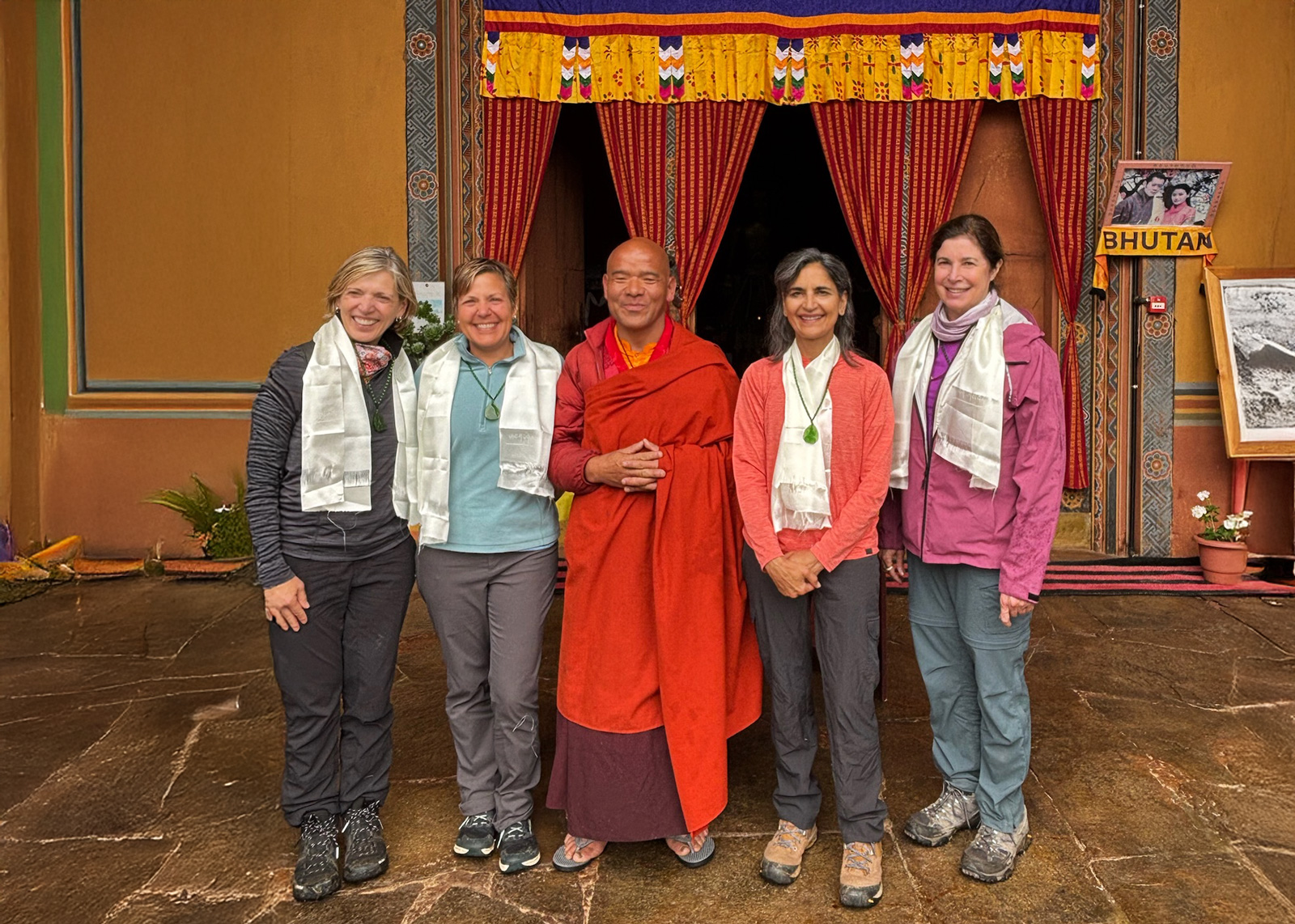 Group of women smiling next to a monk