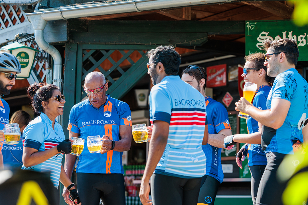Group of bikers with glasses of beers in their hands, while they all smile