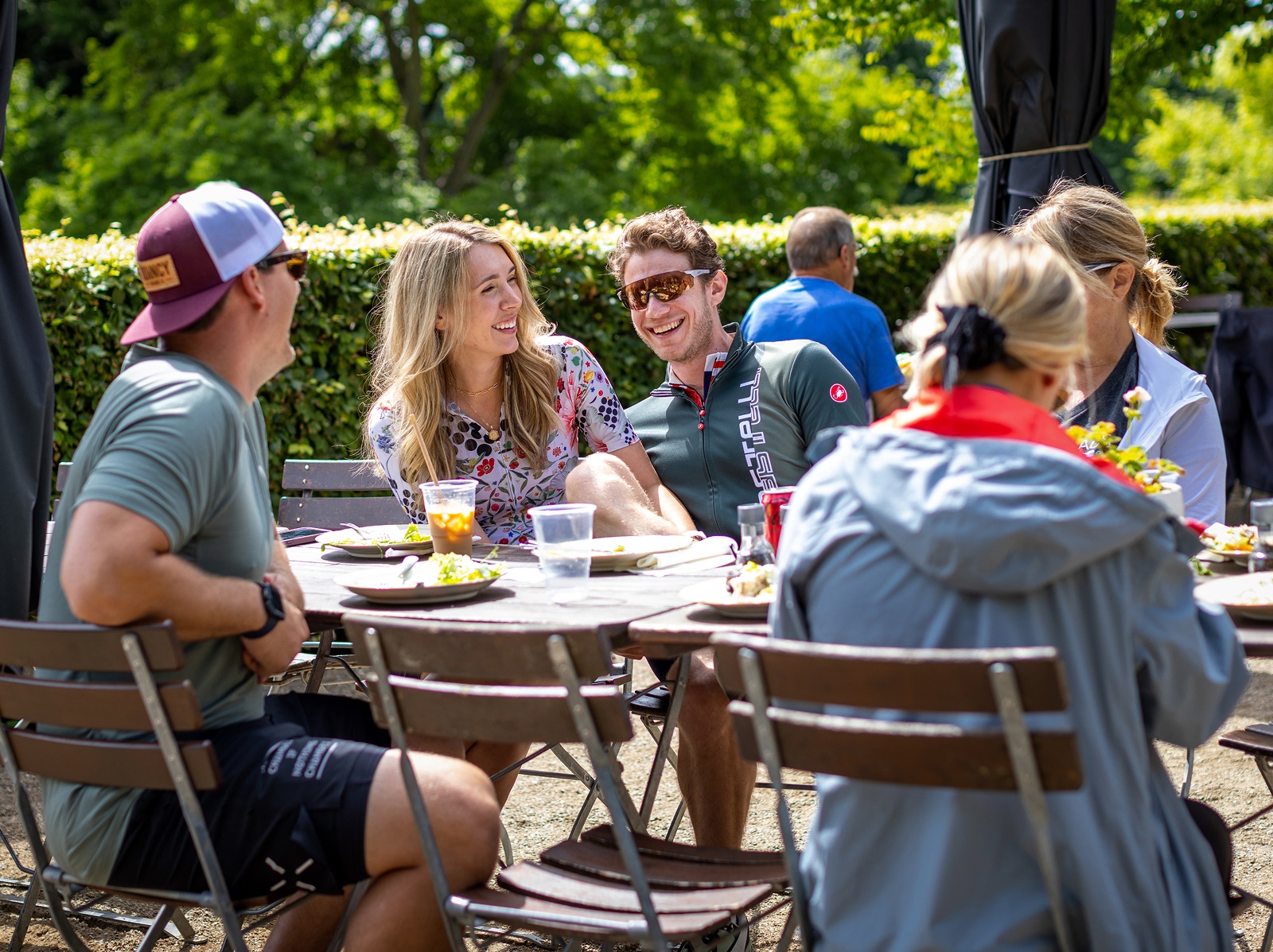 Group of people smiling while sitting down at an outdoor dining table